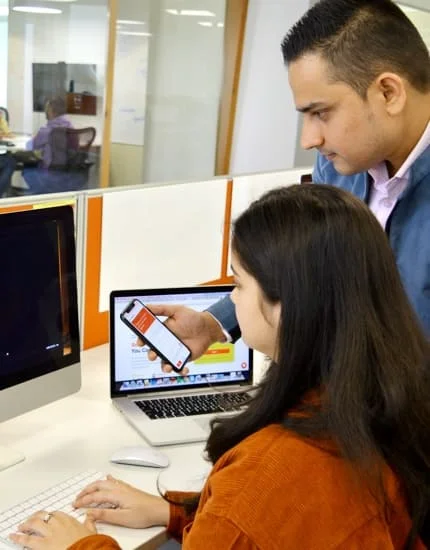 Net Solutions employees working on a mobile and desktop product | Mobile app development services